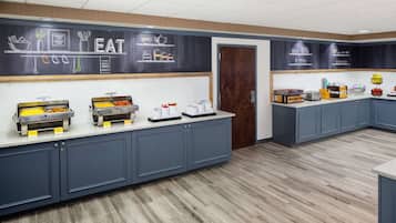 A buffet area with various food stations and a chalkboard with food-related drawings.