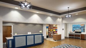 Un vestíbulo de hotel con una recepción, una estación de café y una librería.