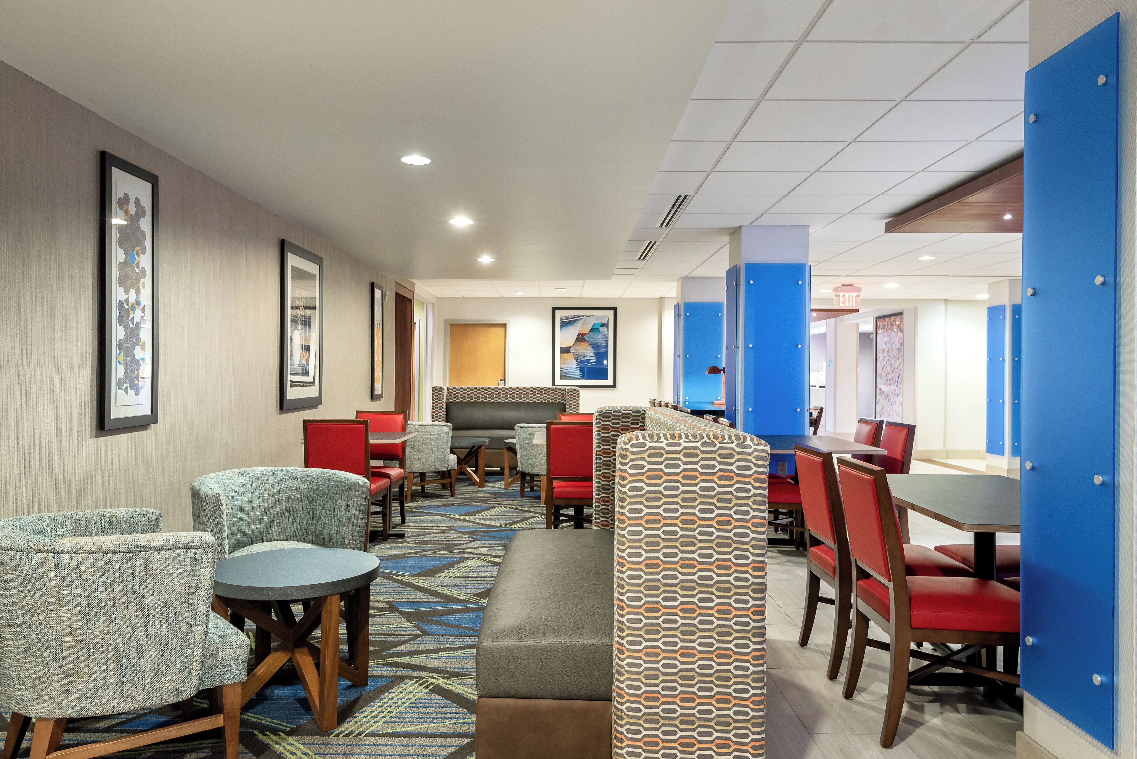 Un hall de hotel con zonas de estar, una recepción y vistas al pasillo.