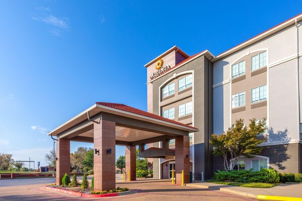 A hotel with a covered entrance, multiple floors, and a clear blue sky. - La Quinta Inn & Suites by Wyndham Oklahoma City - Moore (Moore)