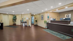 A spacious lobby with a reception desk, potted plants, and a clear path leading to the exit. - Quality Inn & Suites Chambersburg Northeast (Chambersburg)