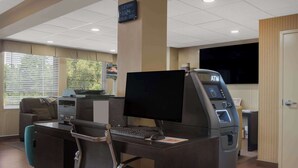A reception desk with a computer, a printer, and an ATM. - Quality Inn & Suites Chambersburg Northeast (Chambersburg)