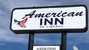 A sign for American Inn of Liberal with a logo featuring an eagle and the American flag. - American Inn of Liberal (Liberal)