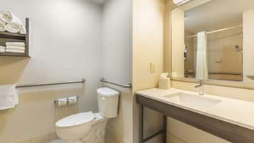 A bathroom with a toilet, a sink, a mirror, and a towel rack.