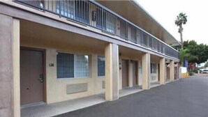 A motel with a row of rooms, each with a door and a window.