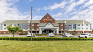 Comfort Inn & Suites -hotelli, jossa on tiiliverhoiltu julkisivu, useita ikkunoita ja hyvin hoidettu nurmikko.