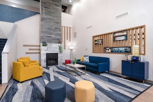 Una sala de estar moderna con chimenea, un sofá, una mesa de centro y un televisor montado en un panel de madera.