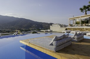 Una piscina al aire libre, sillones reclinables de piscina