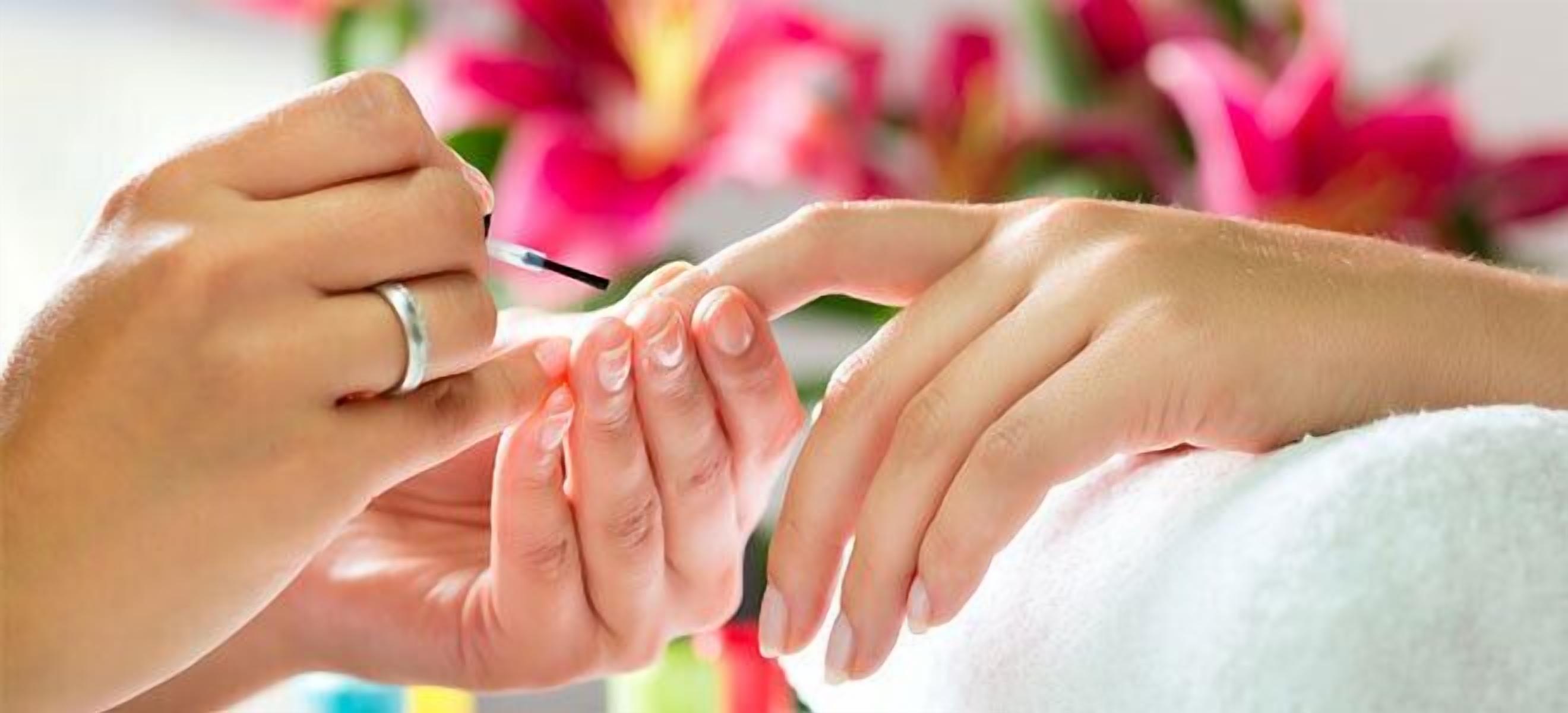 A close-up of hands getting a manicure.