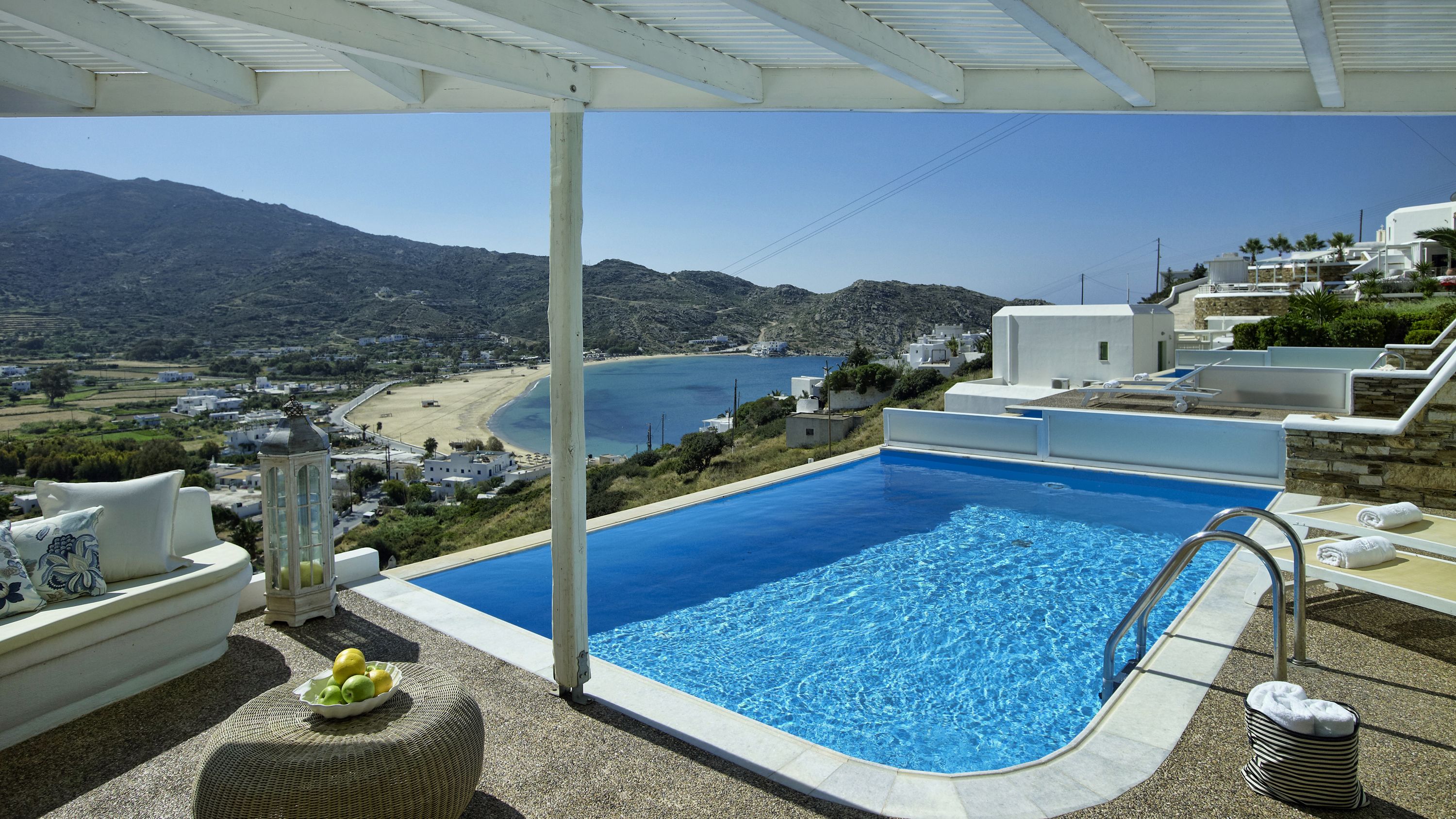 A pool with a view of a beach and mountains.