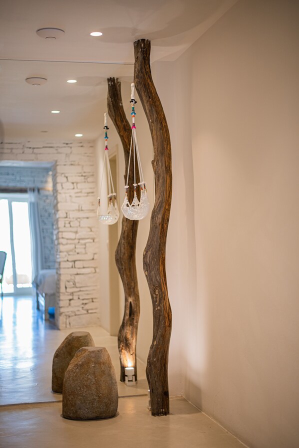 Un pasillo con una escultura de madera rústica, una pared de piedra y un rincón de estar con vistas.