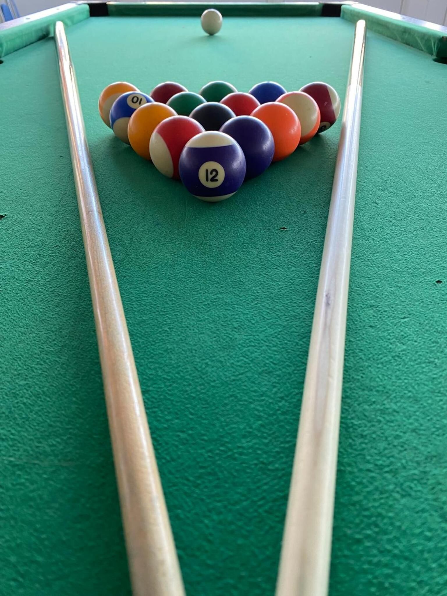 A pool table with a set of numbered balls arranged in a triangle formation.