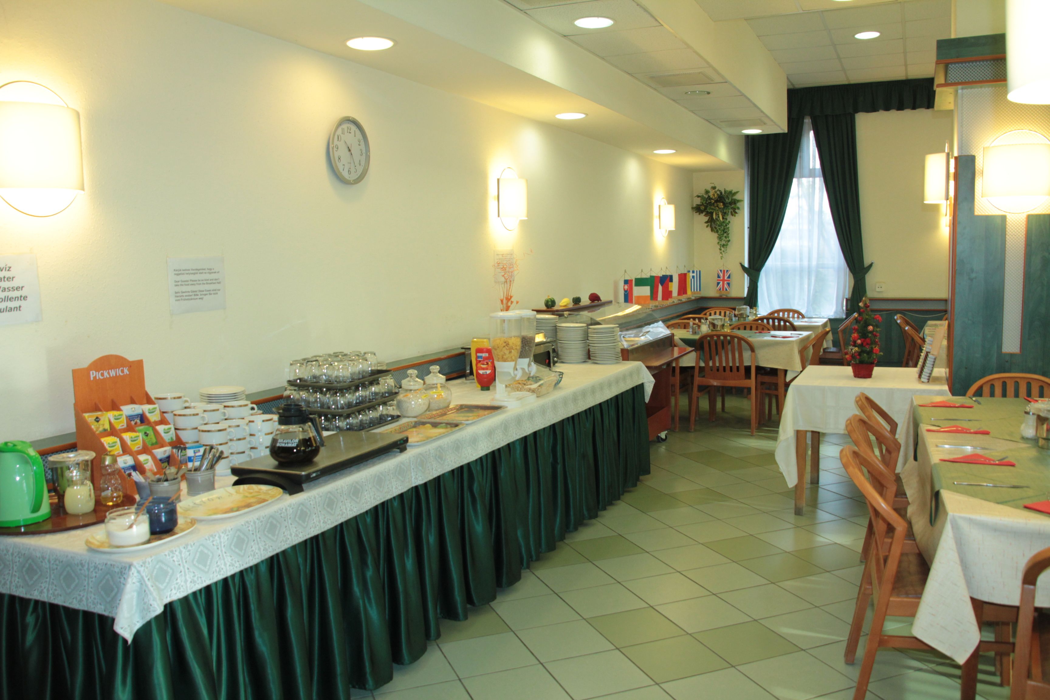 A buffet setup with various food items and a clock on the wall.