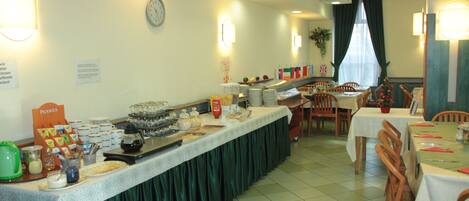 A buffet setup with various food items and a clock on the wall.