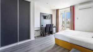 Una habitación de hotel moderna con cama, escritorio, sillas y una puerta corrediza.