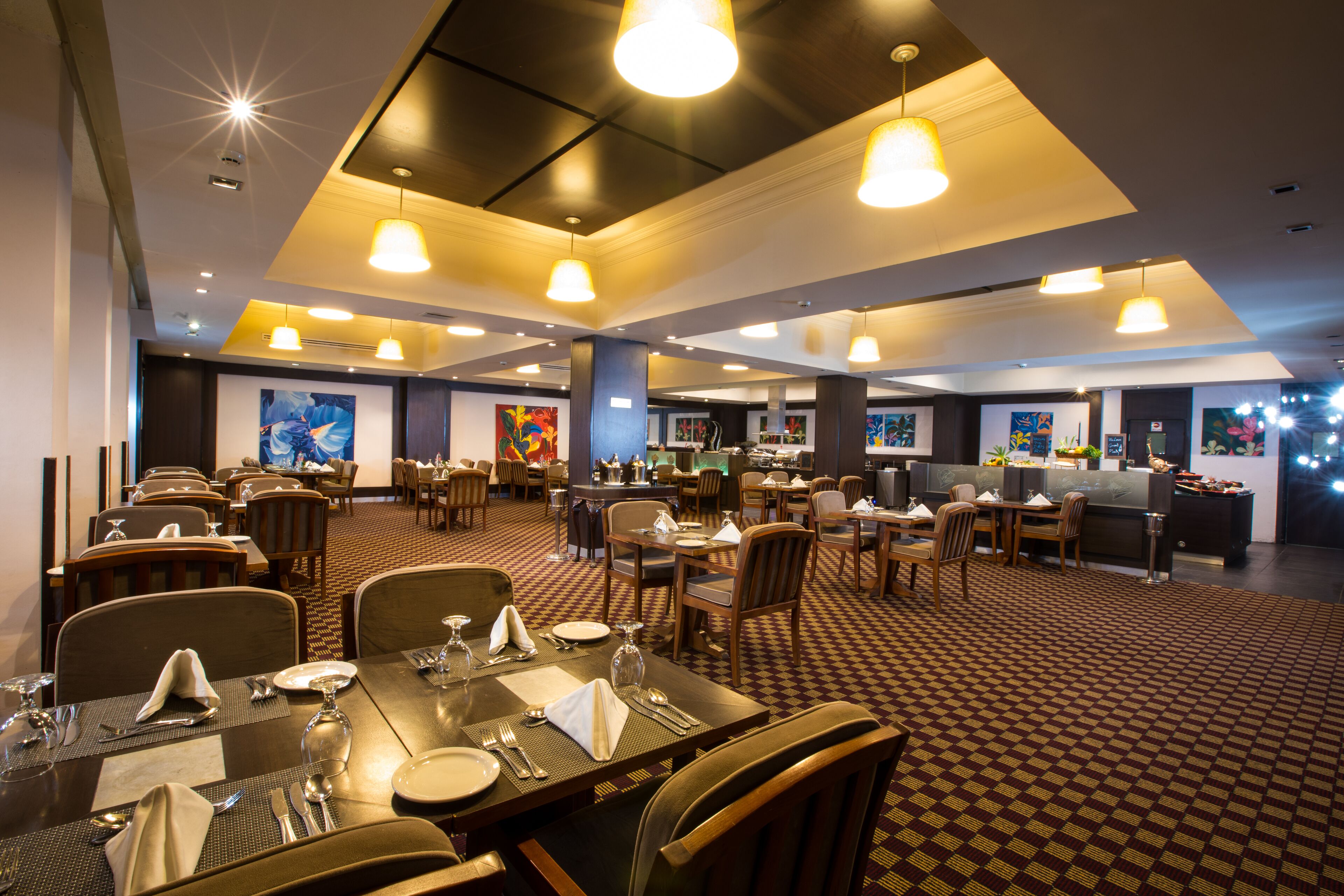 Un restaurant spacieux doté de plusieurs espaces de restauration, de hauts plafonds et d’un éclairage moderne.