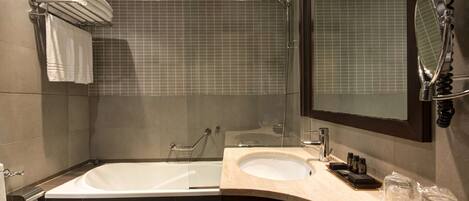 A modern bathroom with a bathtub, a sink, and a glass shower enclosure.
