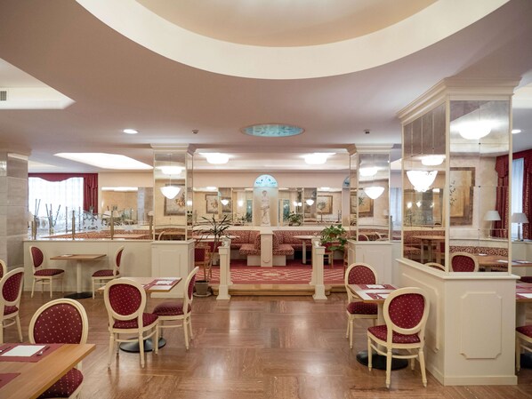 A spacious restaurant with high ceilings, multiple dining areas, and a central bar.