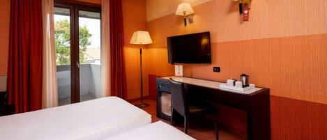 A hotel room with two beds, a desk, a chair, a television, and two wall lamps.