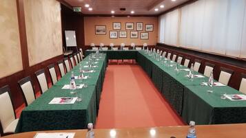 A conference room with long tables, chairs, and water bottles.