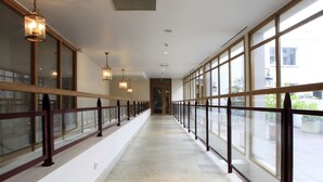 A long corridor with glass railings, wooden balustrades, and hanging lights. - Amiral Hôtel (Paris)