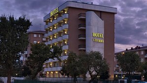 Un hôtel à plusieurs étages, doté de balcons, d’une enseigne bien visible indiquant « HÔTEL » et d’une enseigne « VITERO ».