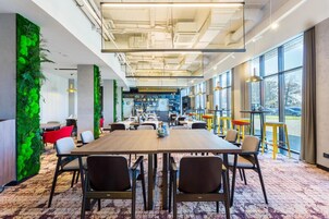 A conference room with a large table, chairs, and a green wall.