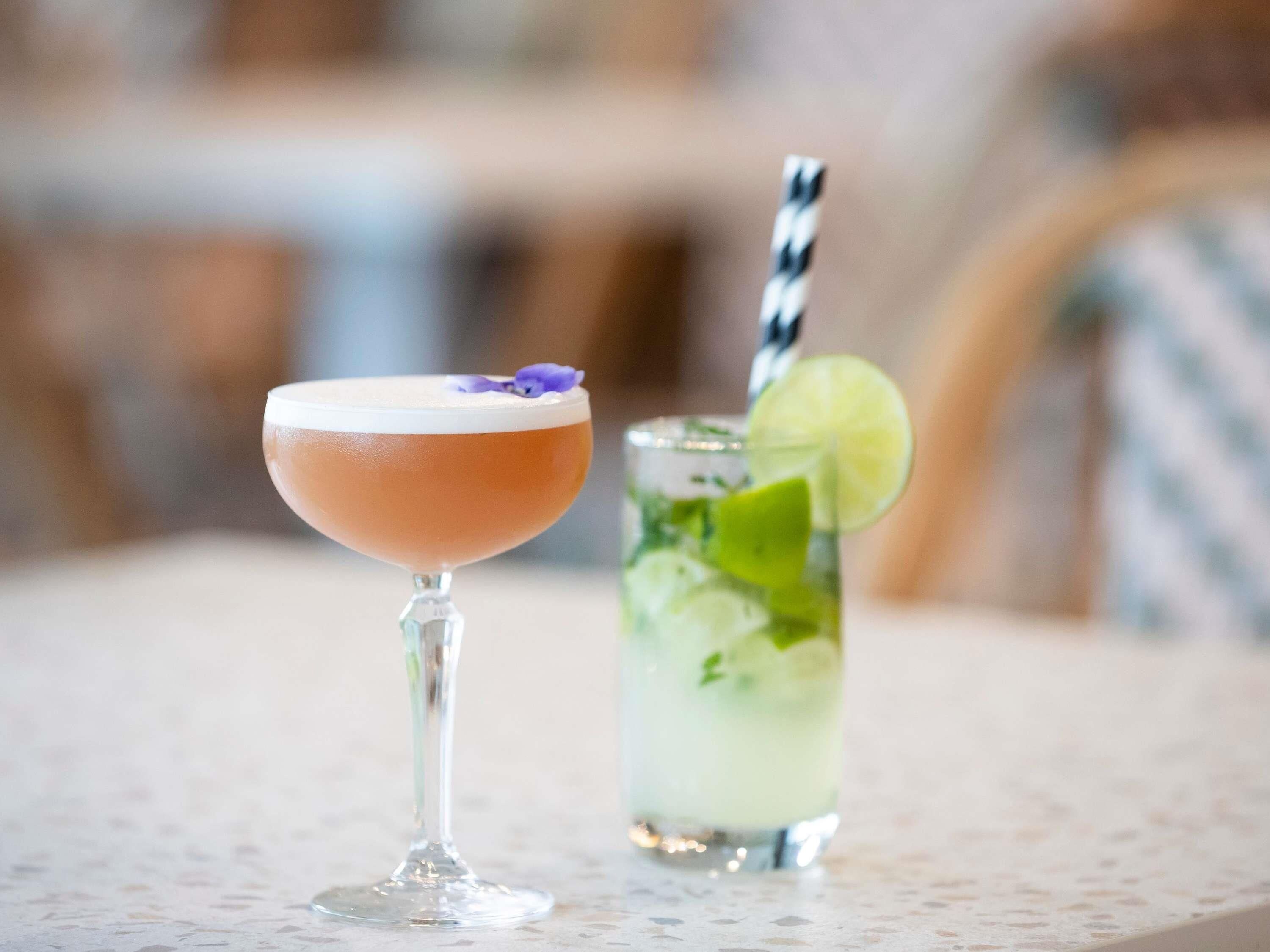 Two drinks on a table with a blurred background.