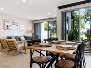 A dining area with a wooden table, black chairs, and woven placemats.