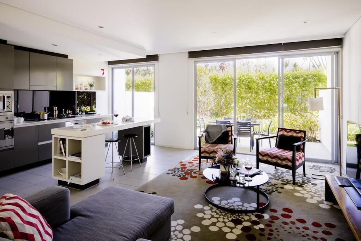 A modern kitchen with a dining area, a sofa, and a coffee table.