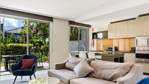Ein modernes Wohnzimmer mit Sofa, Sessel und Couchtisch.