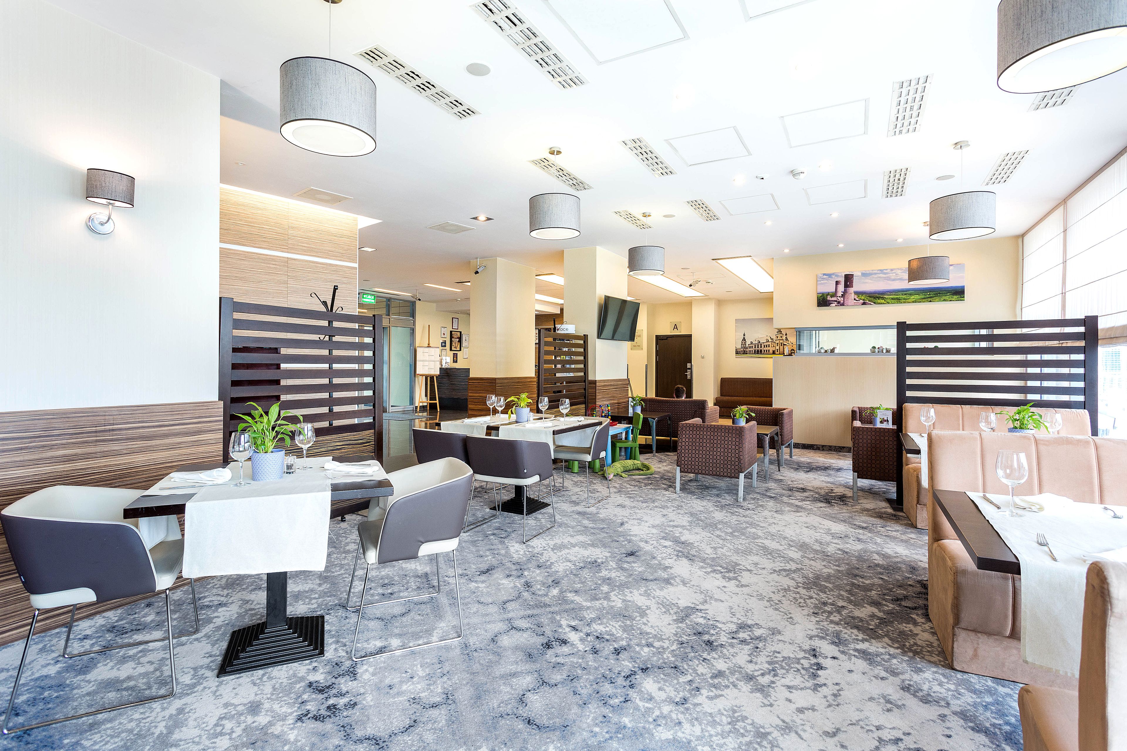 A modern restaurant with a marble floor, contemporary furniture, and a variety of seating options including tables and booths.