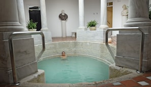 A man in a marble pool with columns and statues around. - Villa Padierna Thermas Hotel - Only Adults (Carratraca)
