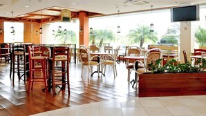 A spacious indoor dining area with wooden flooring, wicker chairs, and tables. - ibis Campo Grande (Campo Grande)