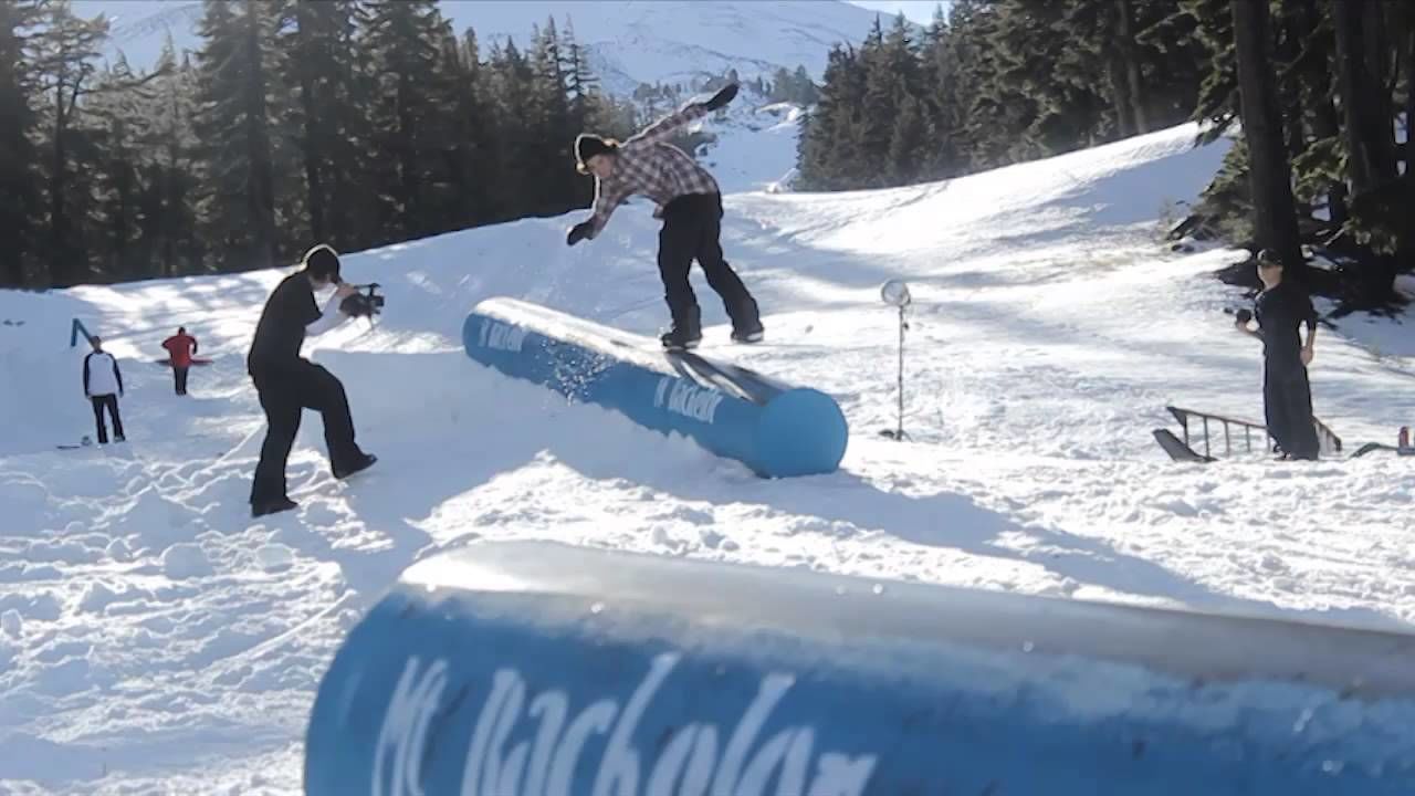 Un snowboarder realizando un truco en una rampa.