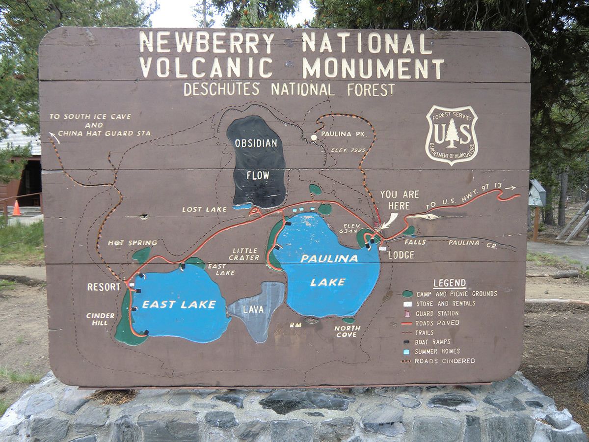 Een kaart van het Newberry National Volcanic Monument met aangegeven bezienswaardigheden zoals Paulina Lake, East Lake en wandelpaden.