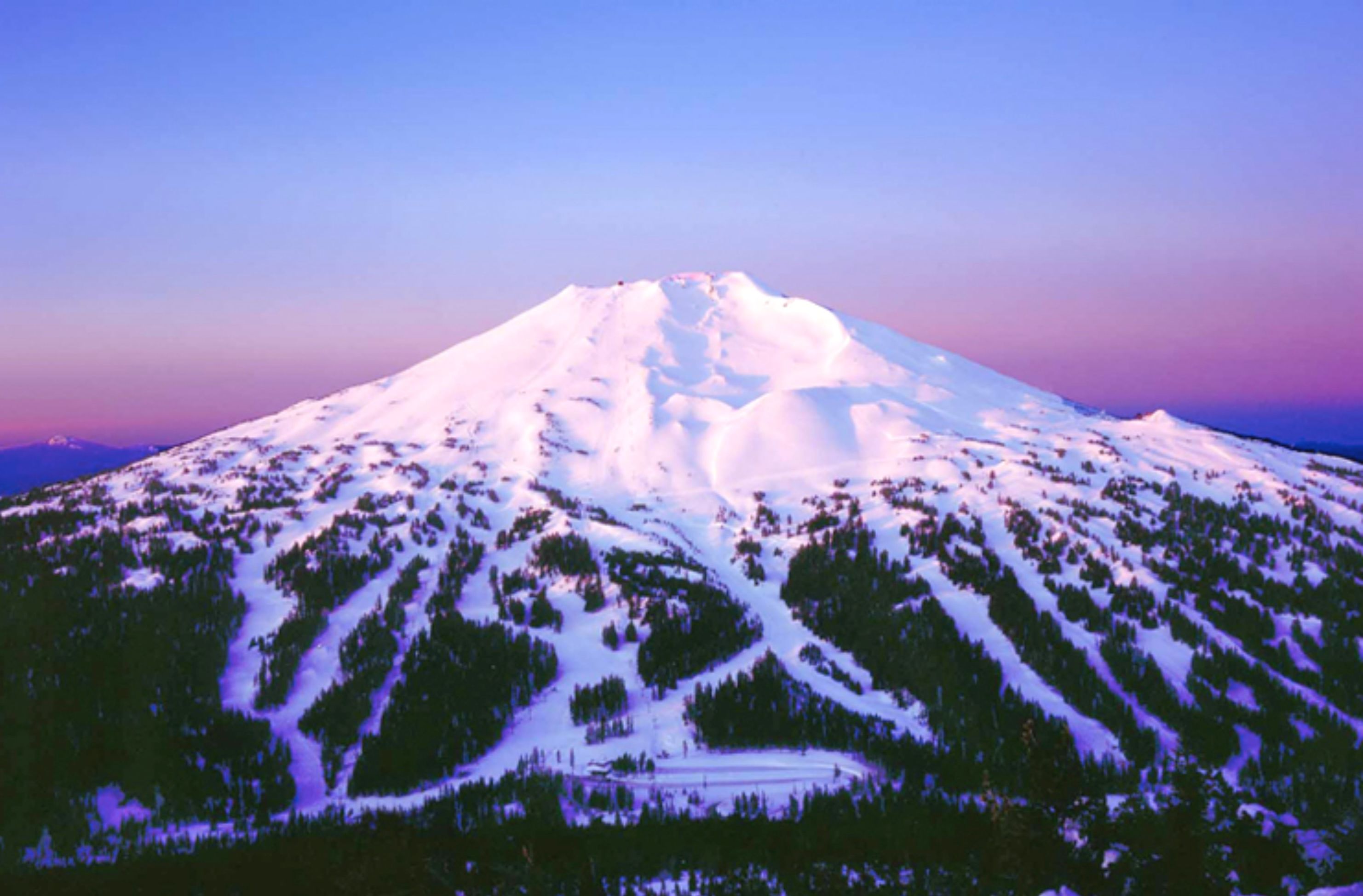 A snow-covered mountain with a clear sky.