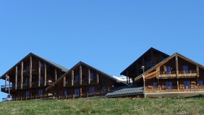 Cabins offer stunning views from their balconies, perched on a hillside.