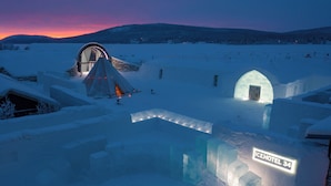 An ice hotel with igloo structures, a tent, and a sign reading "ICEHOTEL 34".