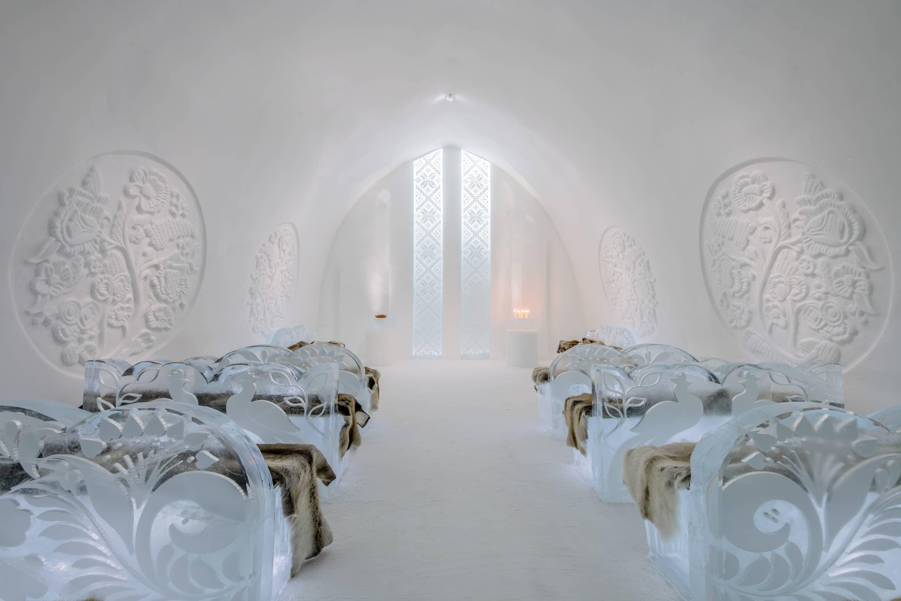 An interior with a central aisle leading to a door with a geometric pattern.