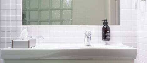 Une salle de bain avec un lavabo blanc, un meuble en bois et un miroir au-dessus.