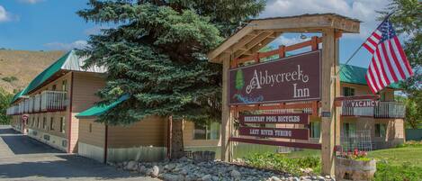 A sign for Abbye Creek Inn with amenities listed including breakfast pool, bicycles, and lazy river tubing.