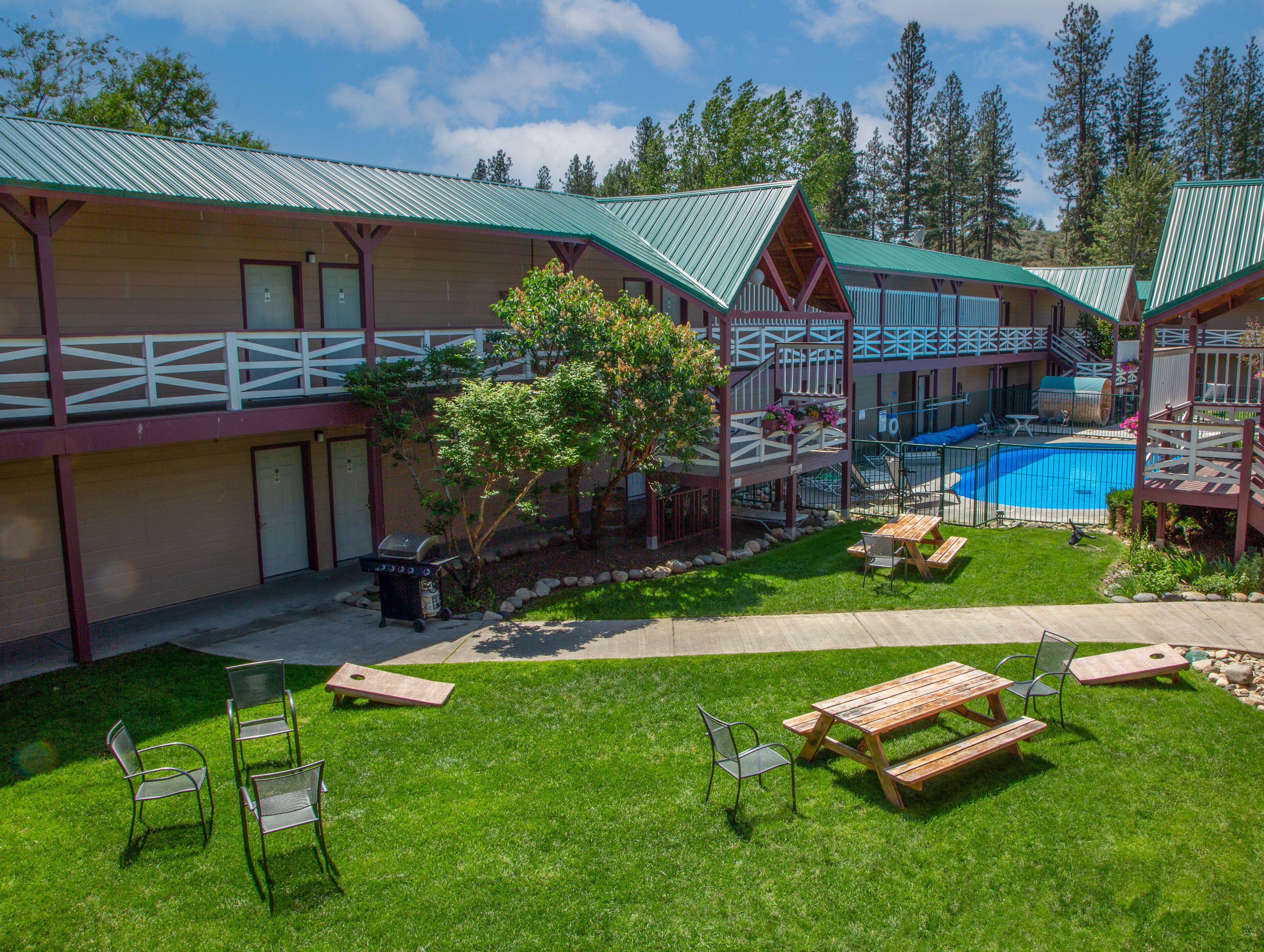 Un chalet doté d’une piscine, de tables de pique-nique et d’une terrasse couverte.
