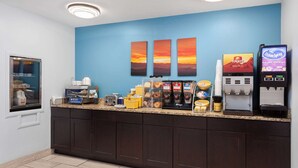 A breakfast bar with coffee machines, a Folgers coffee dispenser, and a Cream Spray machine. - Days Inn & Suites by Wyndham Sellersburg (Sellersburg)