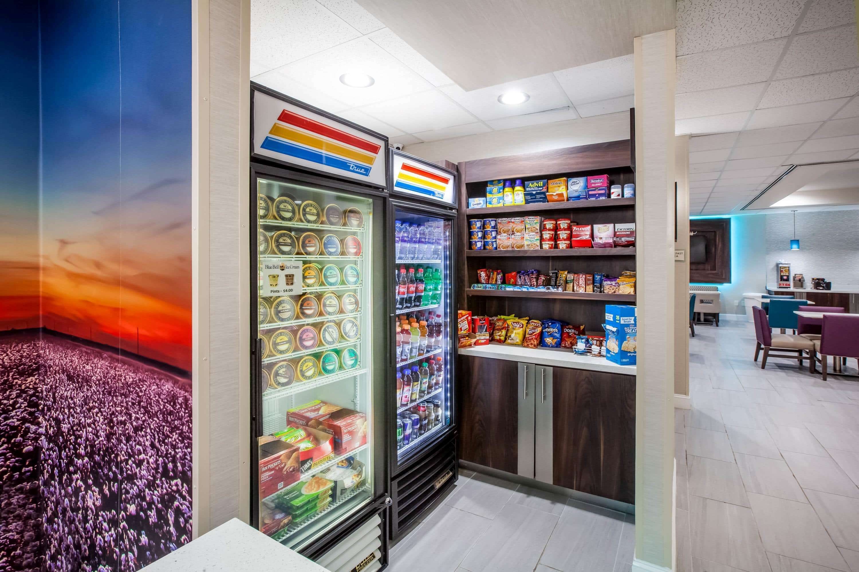A self-service beverage station with refrigerated drink dispensers and a snack shelf.
