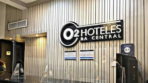 Taulell de recepció a O2 Hoteles BA Central amb un disseny de paret a ratlles verticals.