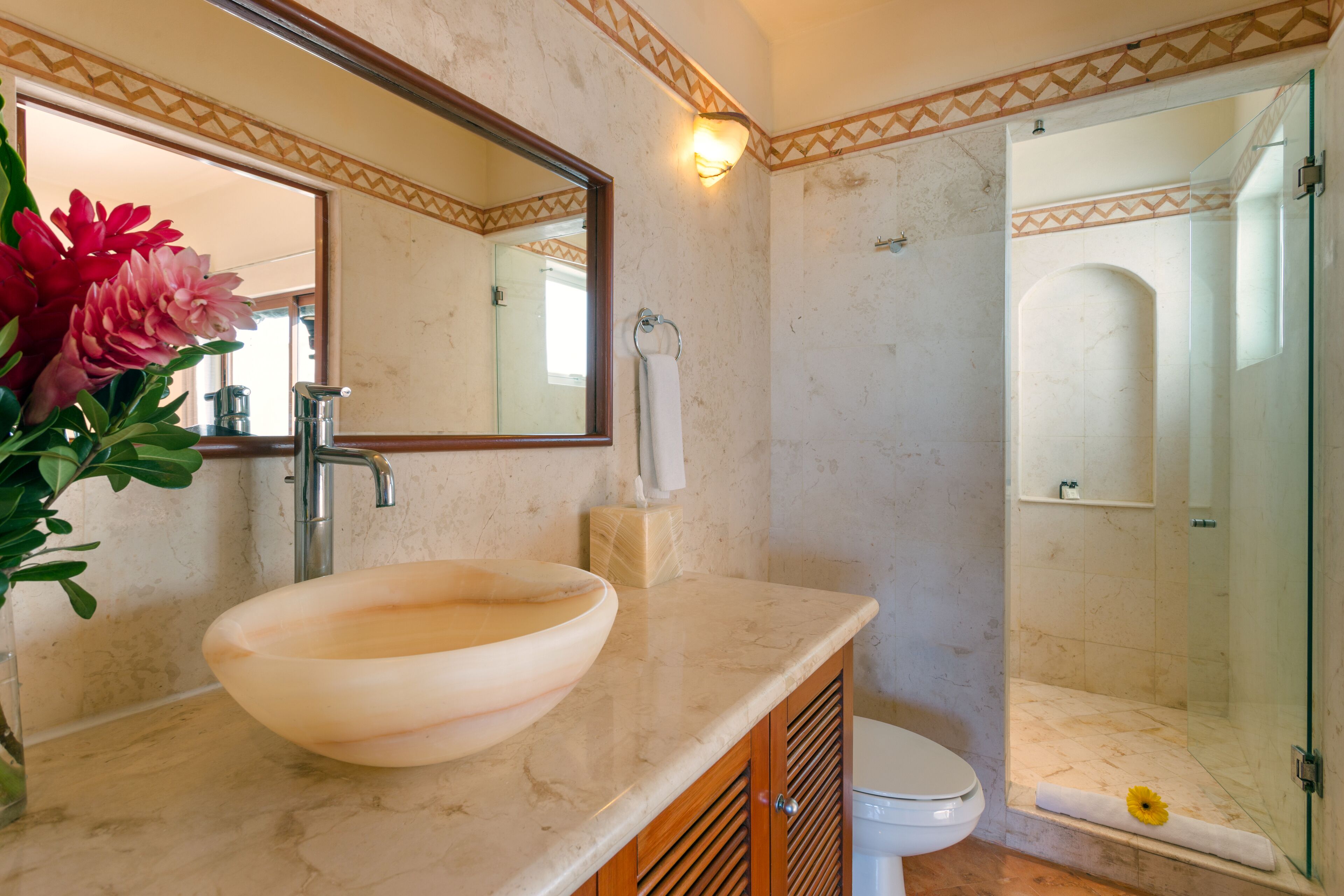 Ein Badezimmer mit einem großen, ovalen Waschbecken, einer Toilette und einer Duschkabine.