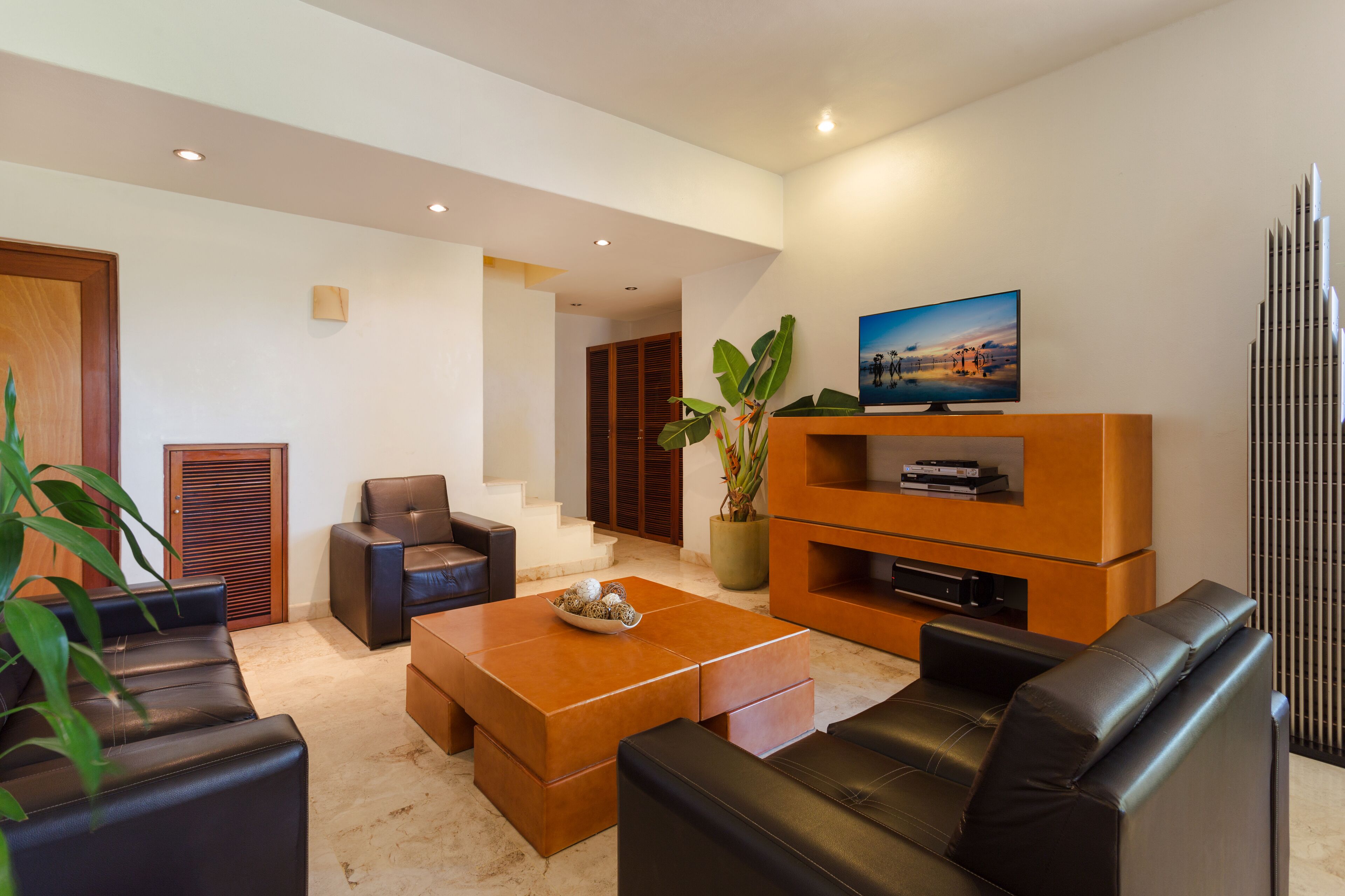 A modern living room with a sofa, coffee table, and TV stand.