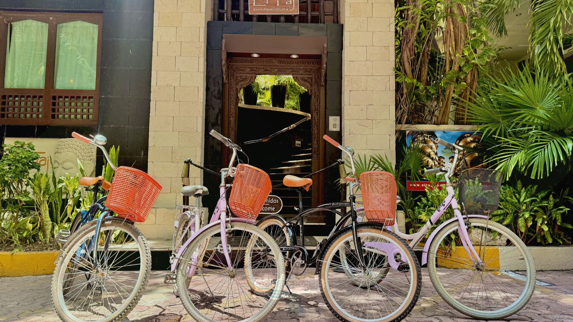 Varias bicicletas estacionadas frente a un edificio con un letrero que dice 'condominiums'.