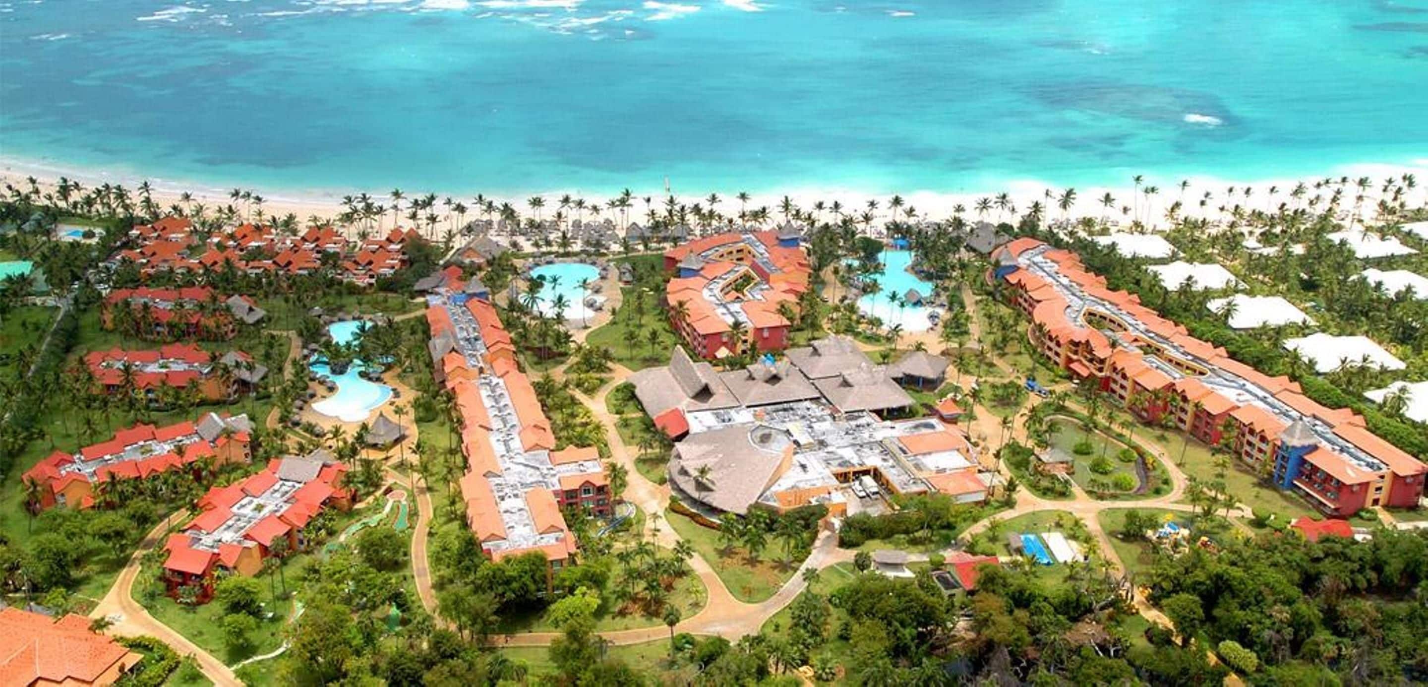 A resort with multiple buildings, swimming pools, and a beach.
